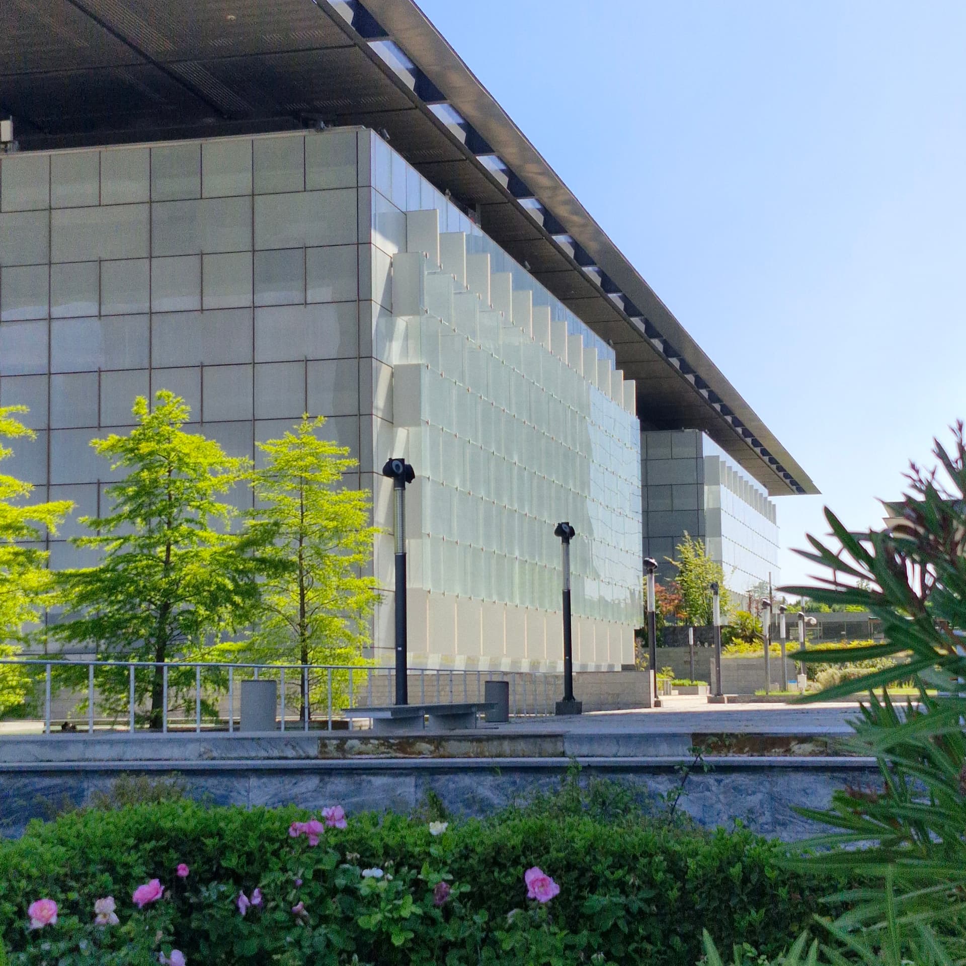 Edificio moderno acristalado junto a un jardín en Madrid